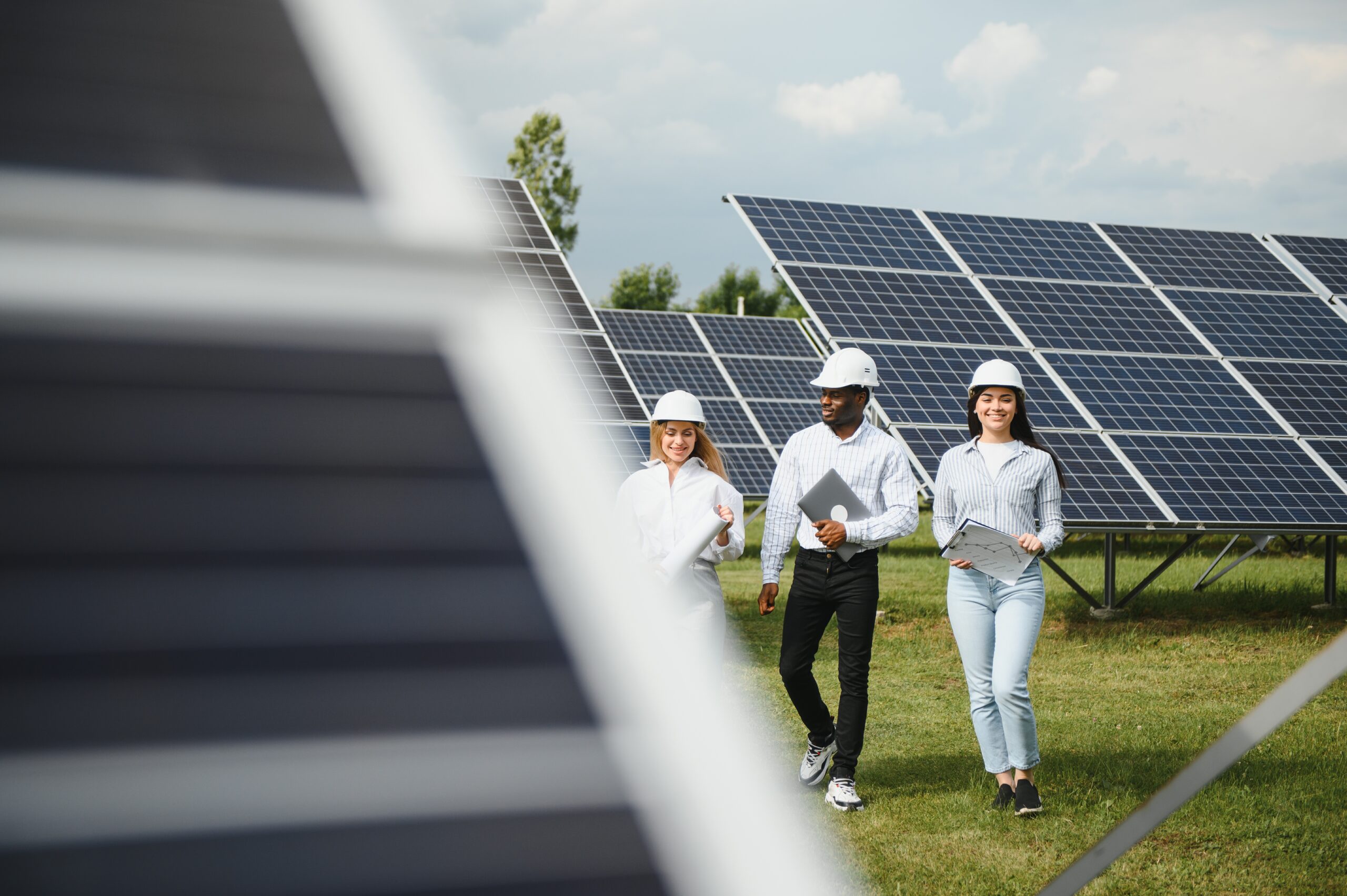Male and female engineers worker working in solar panels power farm. technician working at solar power station.